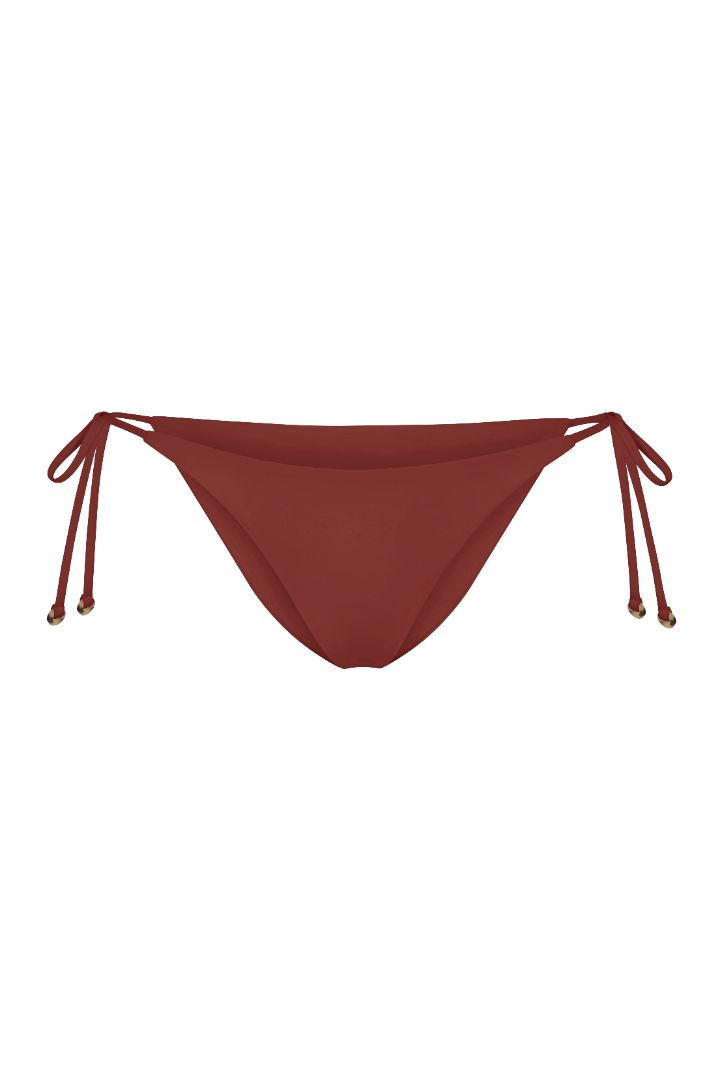 String Tie Bikini Bottom on a white background, featuring adjustable side ties with petite tortoise rings and a versatile high- or low-waist fit for a sleek ’70s-inspired look.