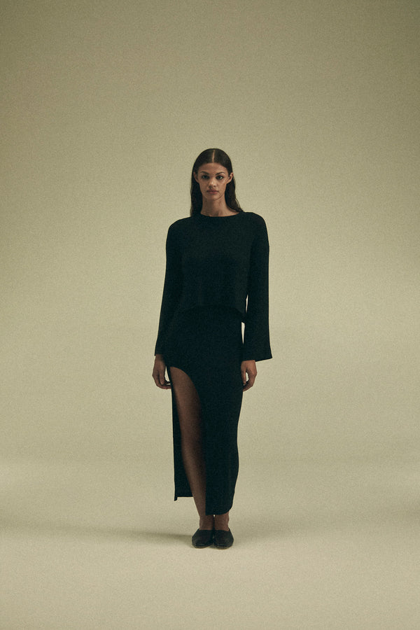 Model wearing the Bell Sleeve Boxy Crop Sweater in Modal Knit, featuring a dynamic wide sleeve and modern cropped fit, offering versatile styling options for cooler weather.