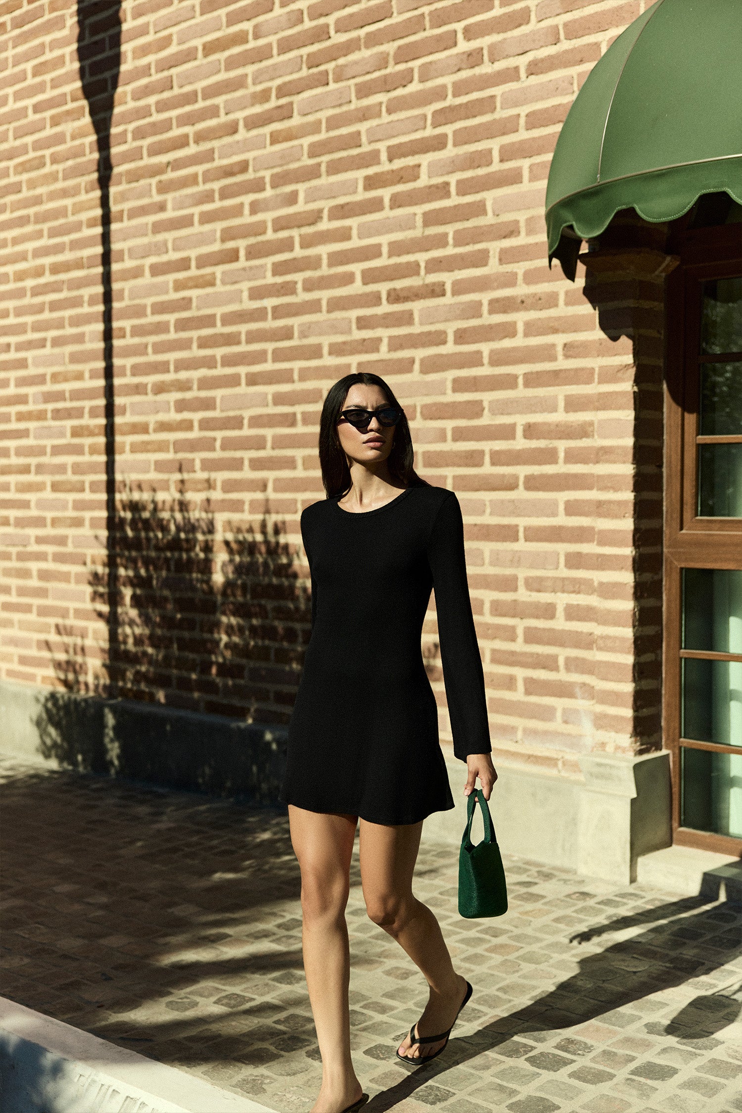 Bell Sleeve Mini Dress in modal knit worn by a model, showcasing the flared sleeves and mini length for a chic, retro-inspired silhouette with timeless, effortless allure. 