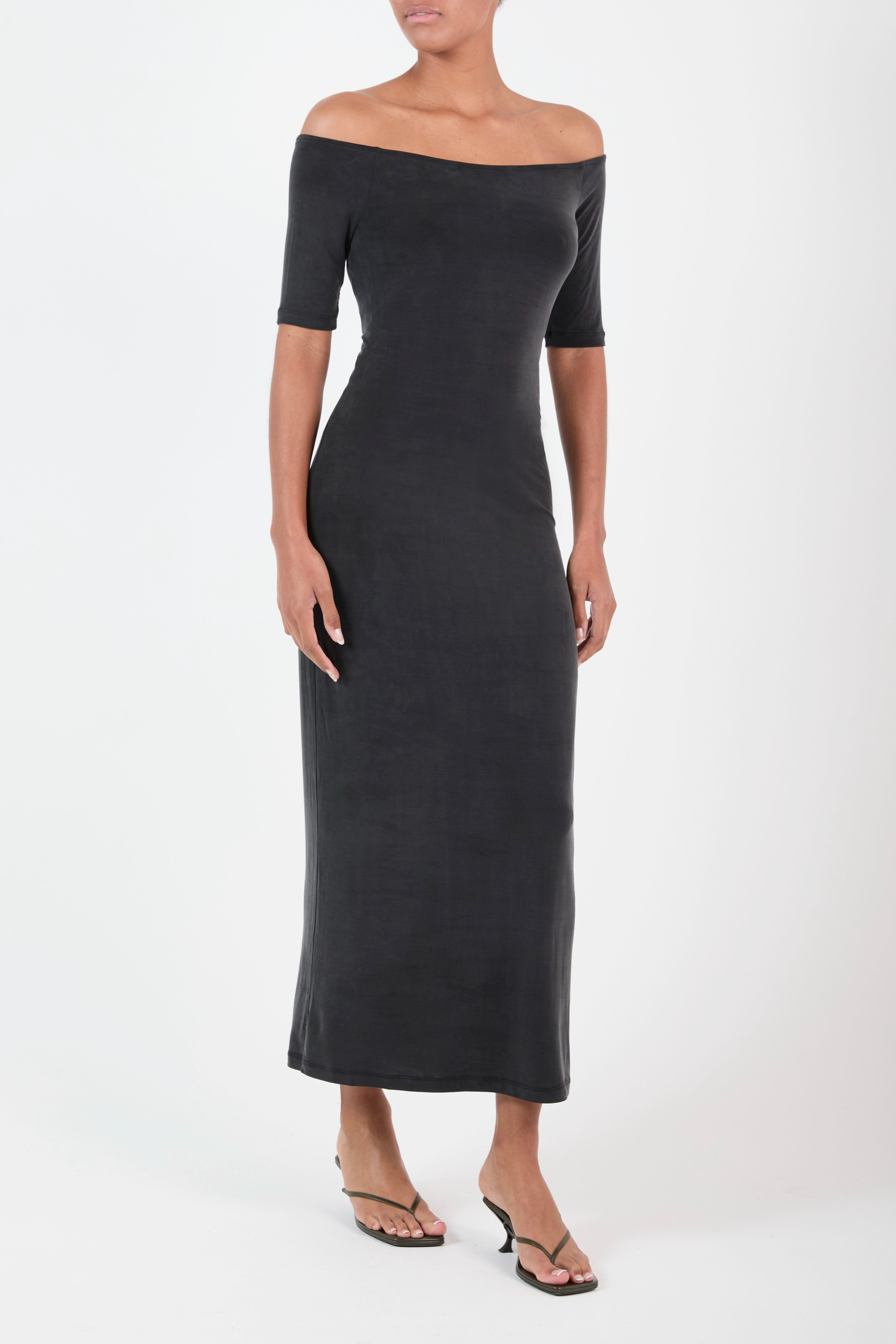 Ecomm Model wearing the Carolyn Off the Shoulder Midi Dress in Luxe Cupro Jersey, the graceful line of the neck continues to the shoulder and together with the elbow-length sleeve creating a moment of alluring and understated chic. 