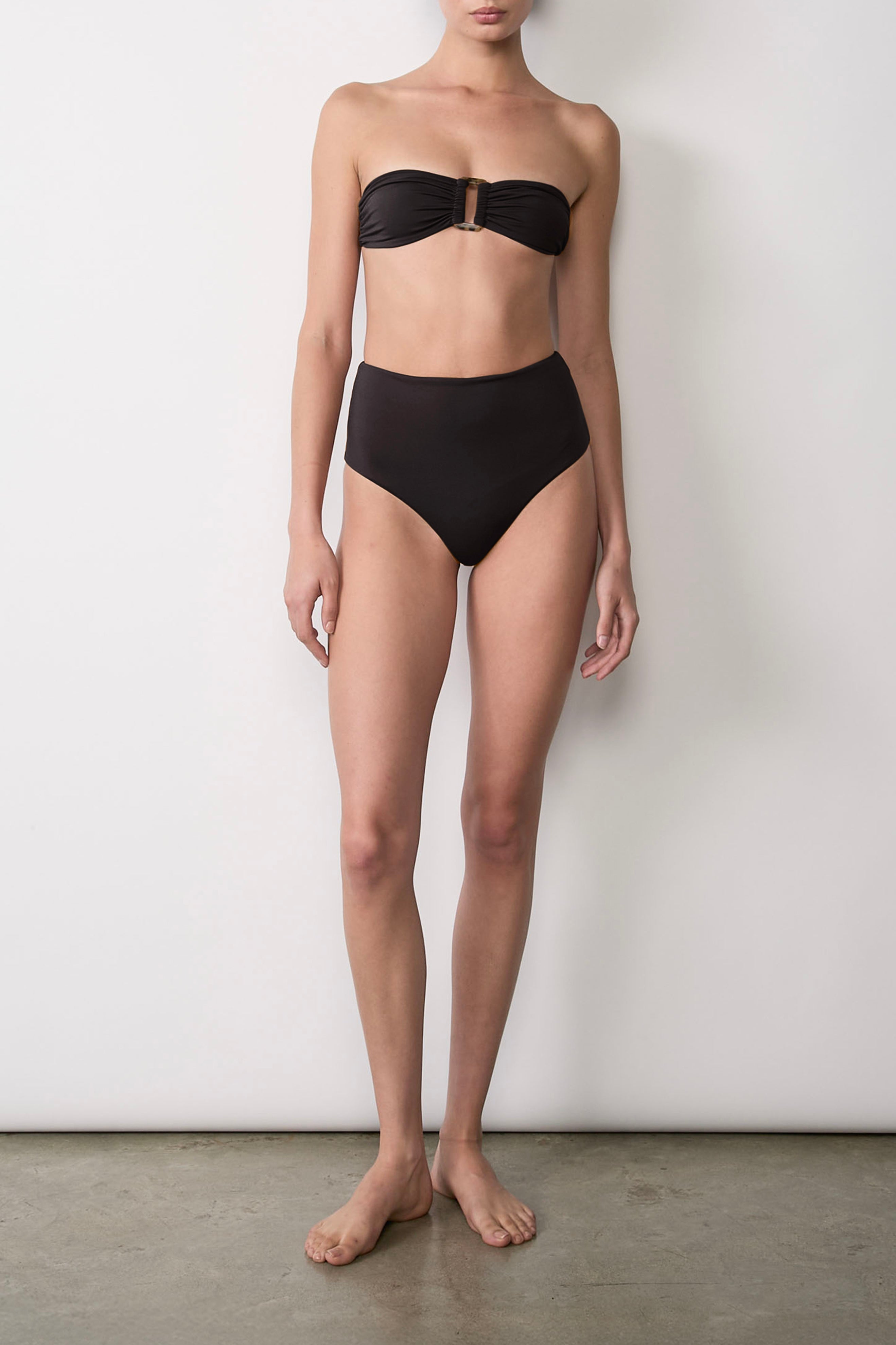 Ecomm Model wearing the High-Waist Bikini Bottom, an Anemos signature, combines retro charm with modern appeal through a high-rise waist and cheeky, flattering cut.