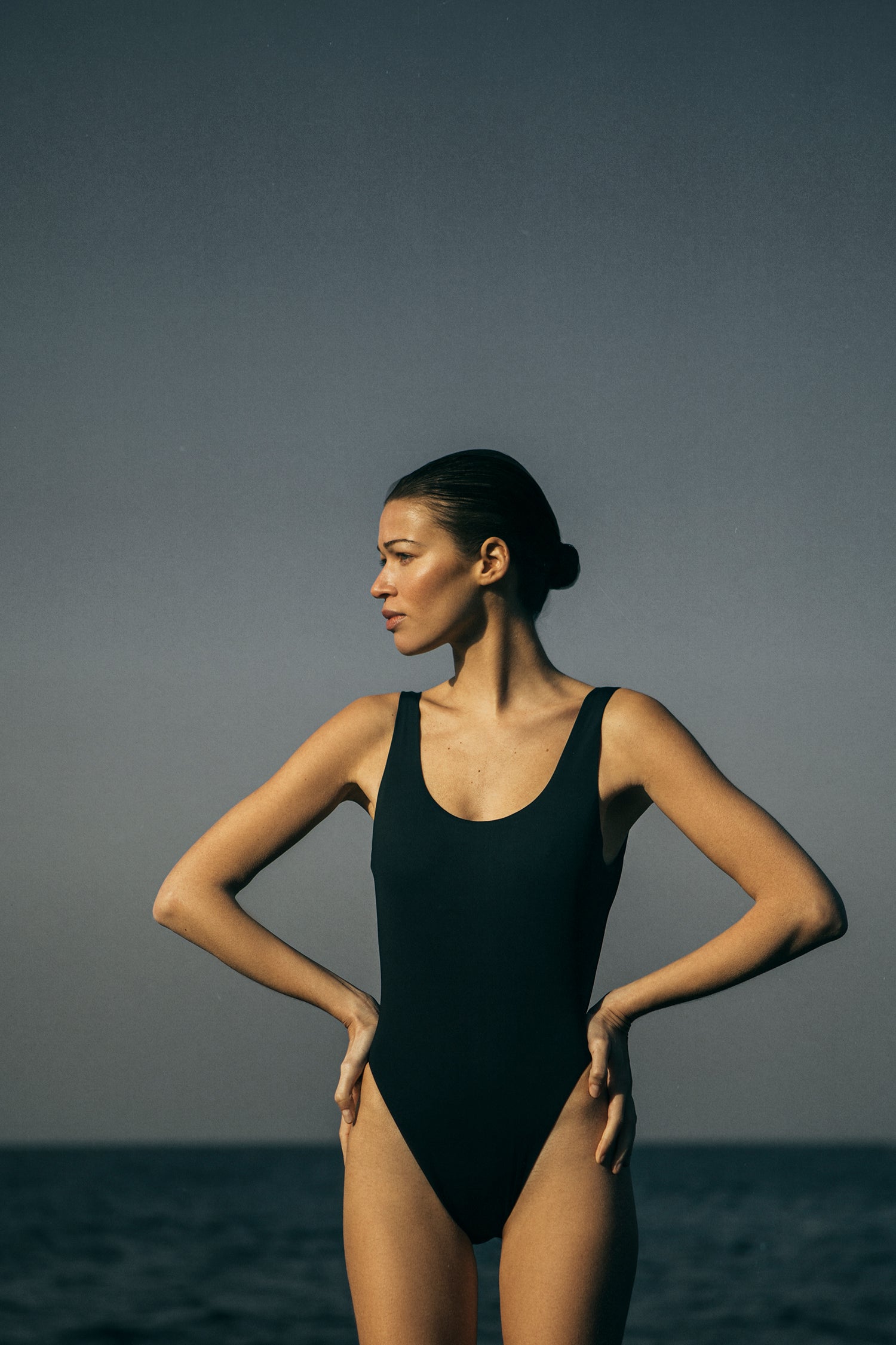 Model wearing the Hume One-Piece, featuring a distinctively high-cut leg and plunging back that is both simple and sexy. 
