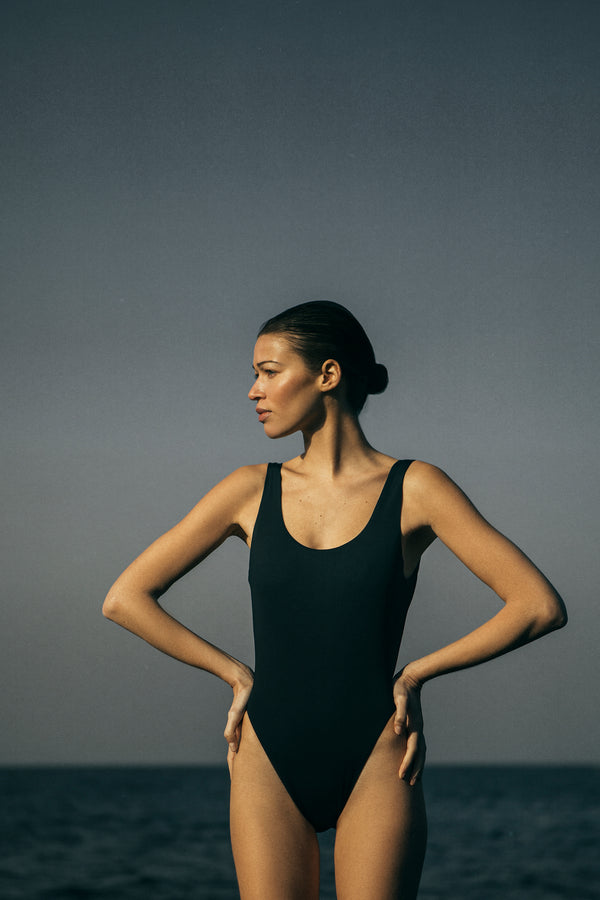 Model wearing the Hume One-Piece, featuring a distinctively high-cut leg and plunging back that is both simple and sexy. 