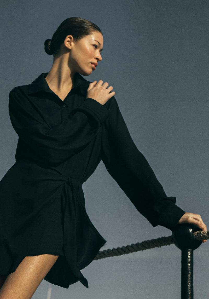 Model wearing the L.A. Button-Down Wrap Mini Dress in Matte Crepe, combining a classic wrap silhouette with an oxford-style button-down design in this signature matte crepe for a sleek, modern look.