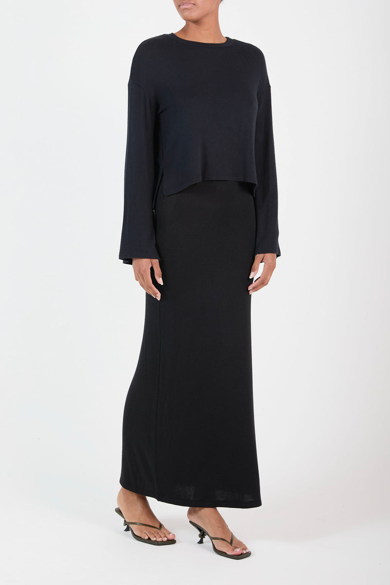 Ecomm Model wearing Black Maxi Skirt in Modal Knit, form-fitting but also light and breathable, it grounds any look in understated fall chic.