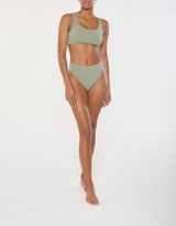 Ecomm Model wearing the Midi High-Cut Bikini Bottom, featuring an easy rise and bold, sculpted sides that elongate the legs.