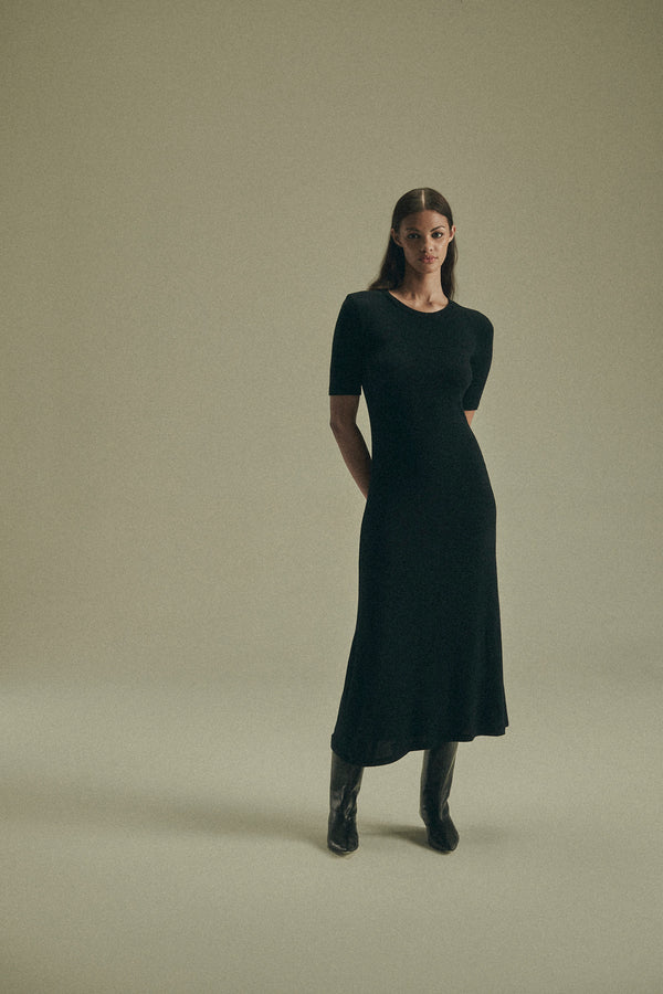 Model wearing the Short-Sleeve Midi Dress in Modal Knit, featuring a sleeve that hits just above the elbow and the distinctive midi hem length, this look gives you coverage that feels uniquely modern.  