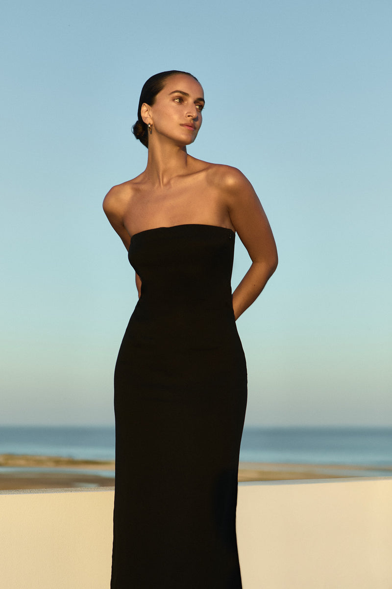 Model wearing the Strapless Midi Dress Black in Stretch Twill embodying minimalist elegance.