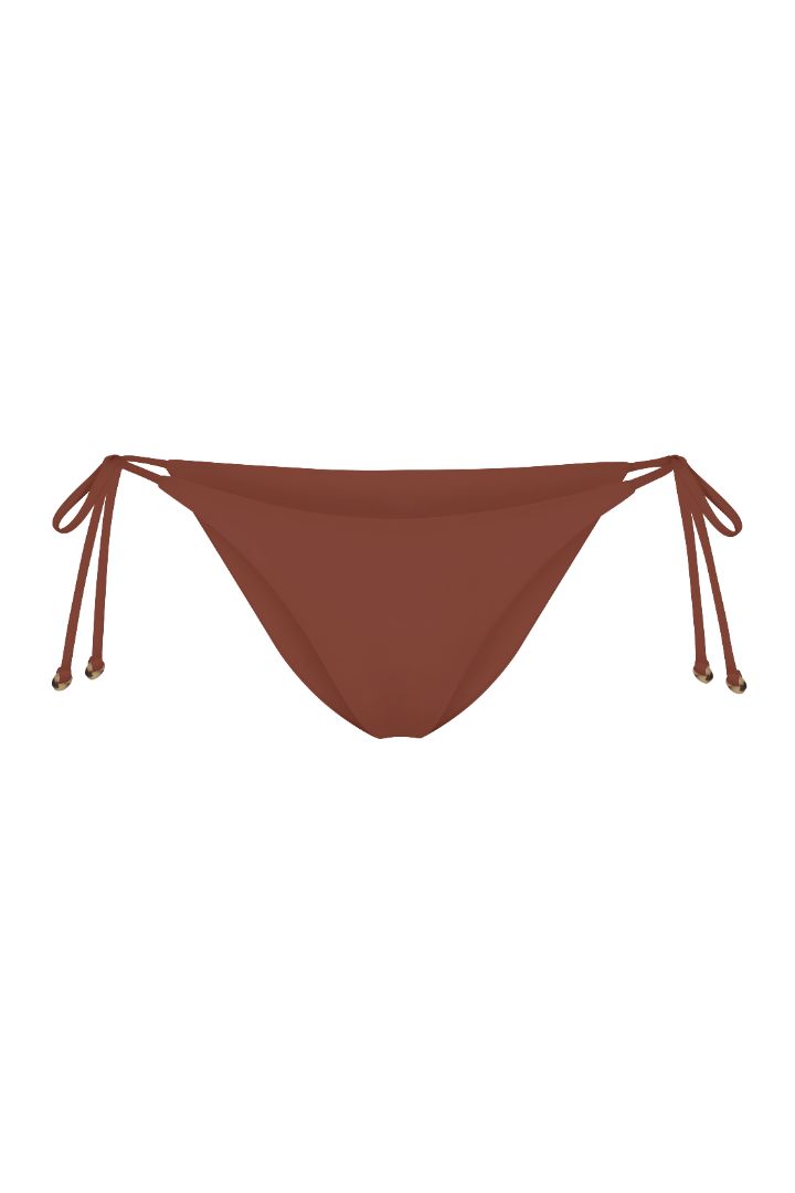 String Tie Bikini Bottom on a white background, featuring adjustable side ties with petite tortoise rings and a versatile high- or low-waist fit for a sleek ’70s-inspired look. 