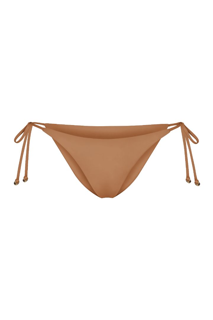 String Tie Bikini Bottom on a white background, featuring adjustable side ties with petite tortoise rings and a versatile high- or low-waist fit for a sleek ’70s-inspired look. 