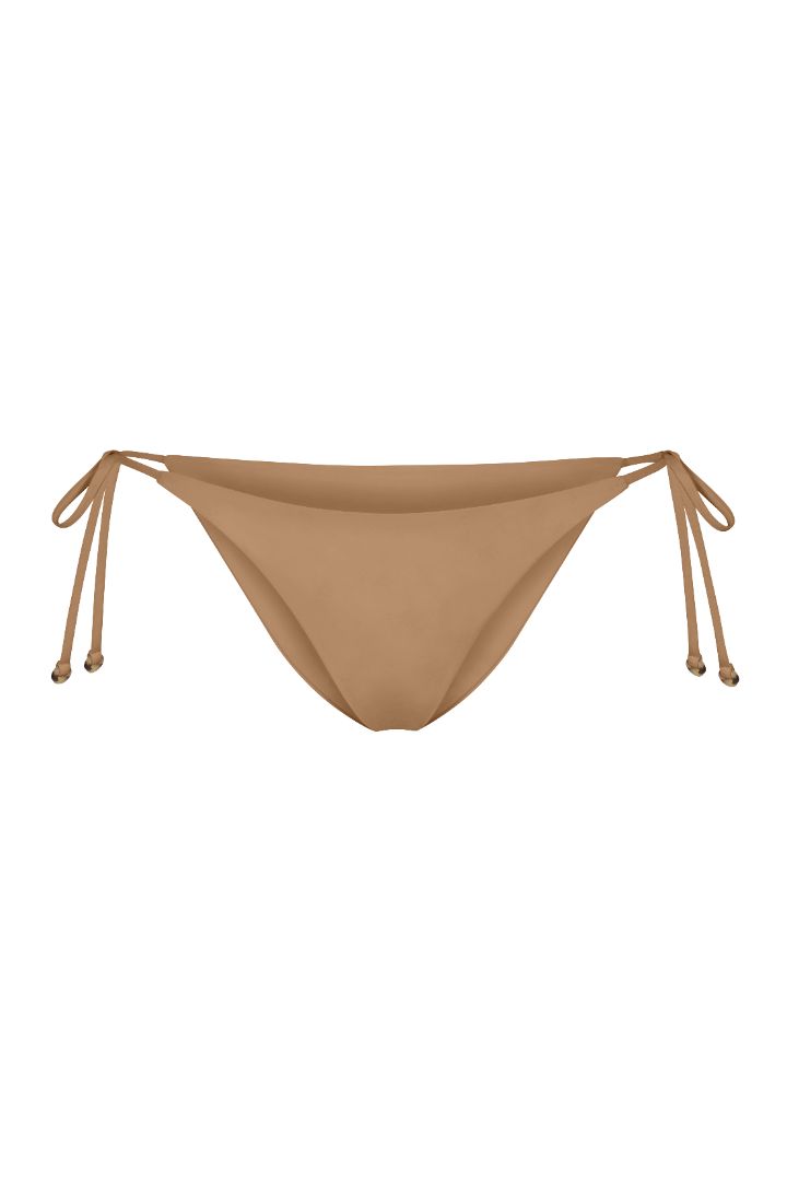 String Tie Bikini Bottom on a white background, featuring adjustable side ties with petite tortoise rings and a versatile high- or low-waist fit for a sleek ’70s-inspired look. 