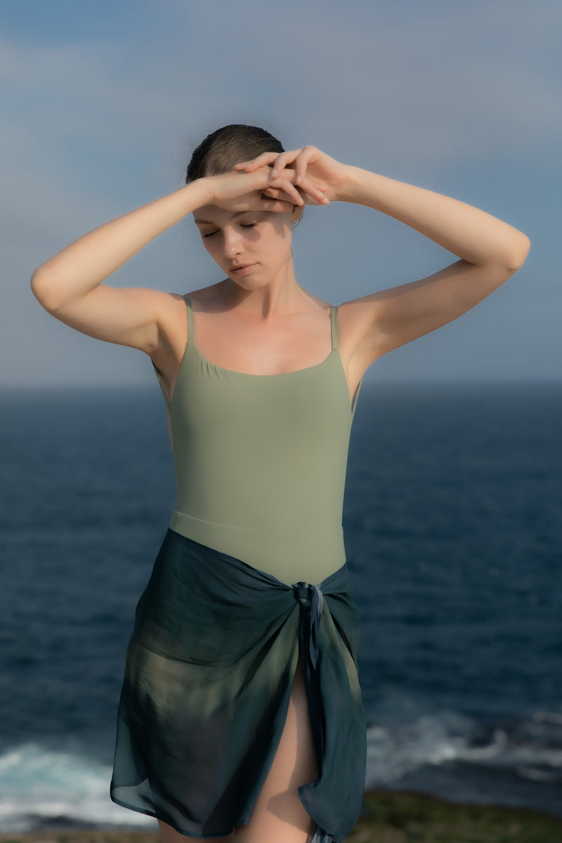 Model wearing the Wrap Mini Skirt in Sheer Ombre Chiffon, a chic addition to any beach look.