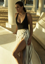 Model wearing the Wrap Tie Maxi Skirt Natural Stripe in Striped Stretch Twill, designed to layer lightly over swim or pair back with refined separates.