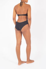 Ecomm Model wearing the Sweetheart Halter One-Piece, featuring a ruched halter neckline and architectural cutouts, this style offers a chic alternative to a classic shape.